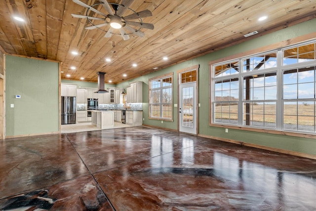 unfurnished living room with wooden ceiling, concrete floors, and ceiling fan