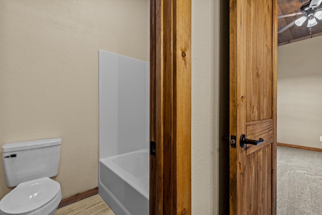 bathroom featuring a washtub and toilet