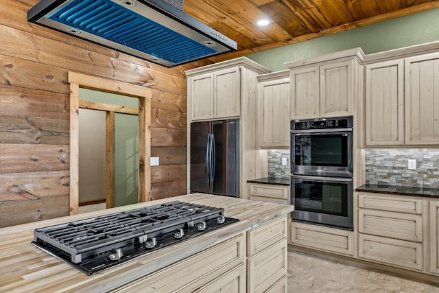 kitchen with tasteful backsplash, ventilation hood, black appliances, and wooden walls