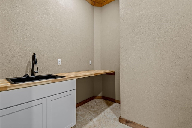 bar with sink and butcher block countertops