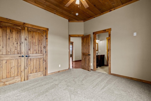 unfurnished bedroom featuring wood ceiling, ensuite bath, ceiling fan, and light carpet