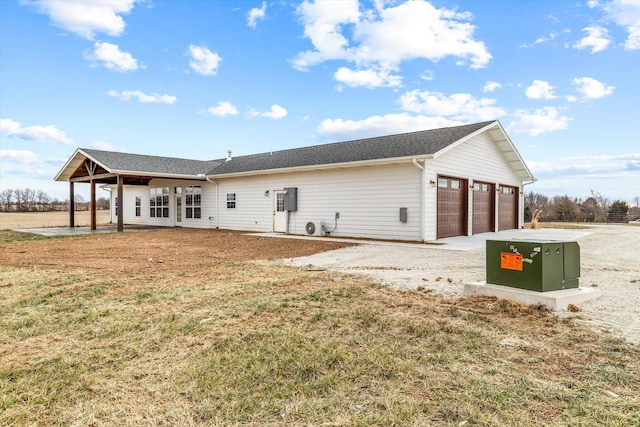 rear view of property with a yard and a garage