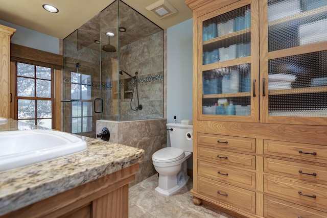 bathroom featuring tile patterned flooring, sink, toilet, and walk in shower