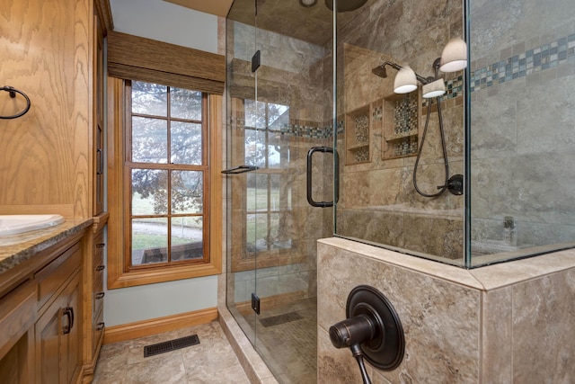 bathroom with vanity and a shower with door