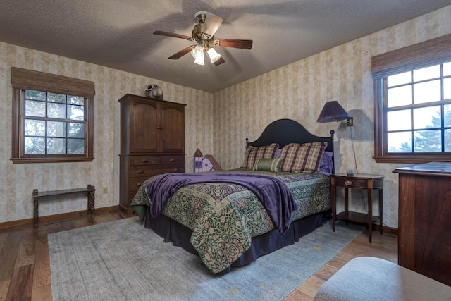 bedroom featuring multiple windows, ceiling fan, and light wood-type flooring