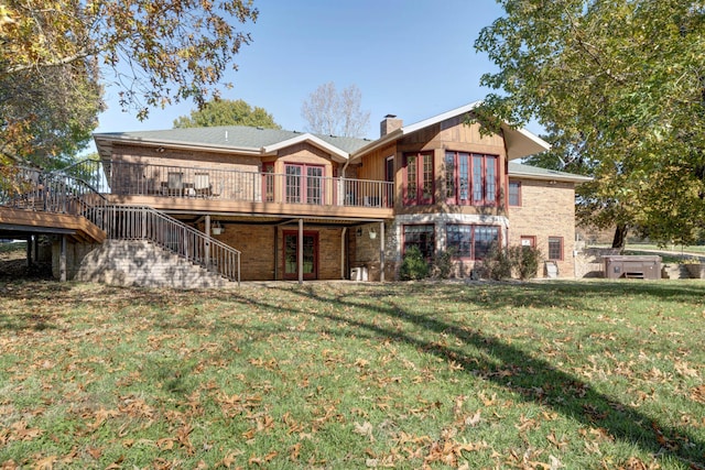 rear view of house with a wooden deck and a lawn