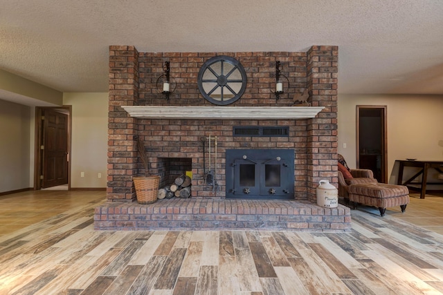 living room featuring a brick fireplace, hardwood / wood-style floors, and a textured ceiling