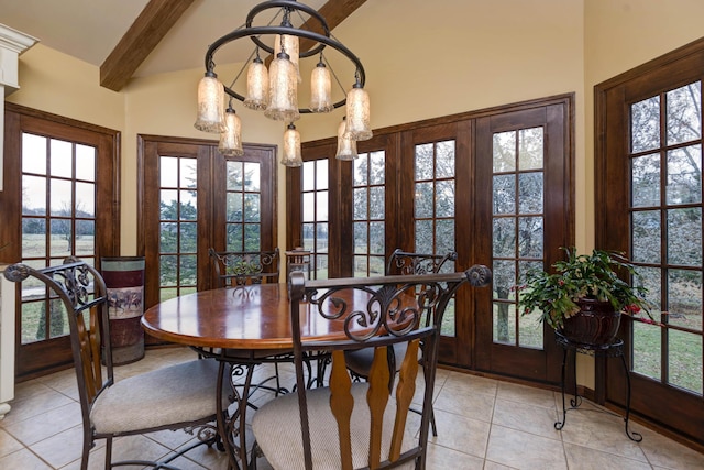 tiled dining space featuring an inviting chandelier, french doors, and beamed ceiling