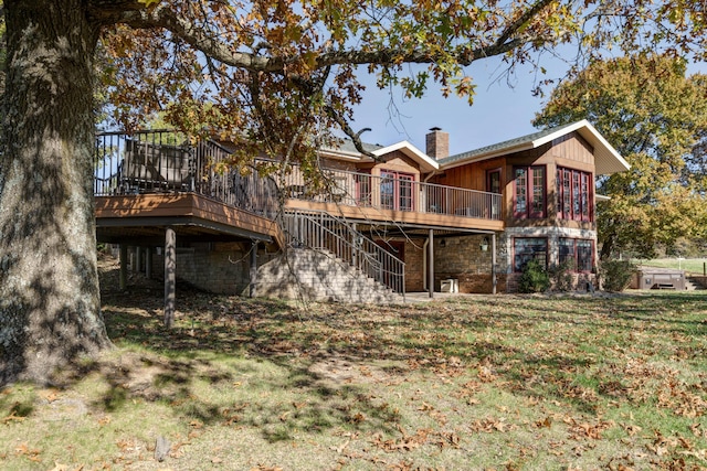 back of house with a wooden deck and a lawn