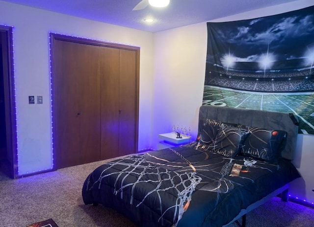 carpeted bedroom with ceiling fan and a closet