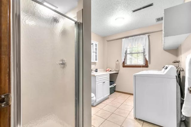 laundry room with light tile patterned floors and a textured ceiling