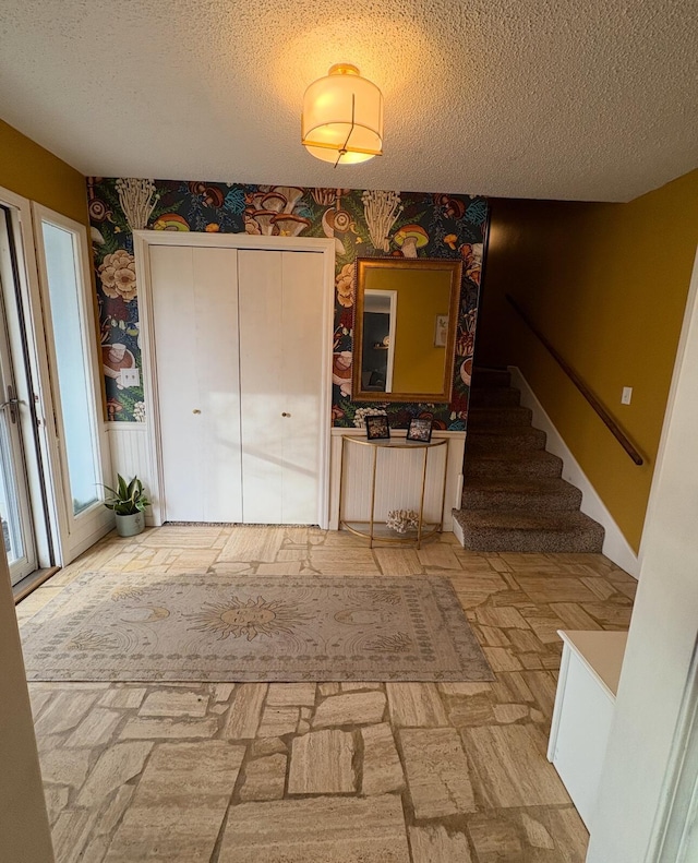 foyer entrance with a textured ceiling