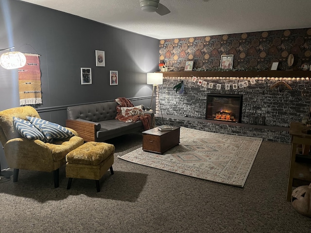 living room with ceiling fan, a fireplace, carpet, and a textured ceiling