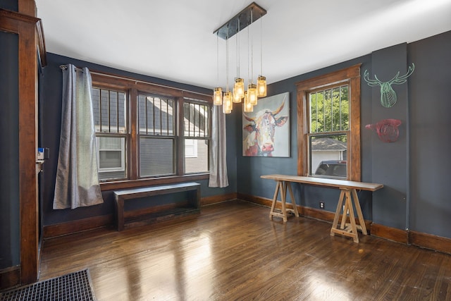 unfurnished dining area with dark hardwood / wood-style flooring and a chandelier