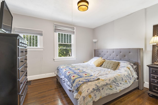 bedroom with dark hardwood / wood-style floors