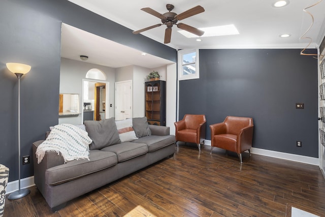 living room featuring crown molding, a skylight, dark hardwood / wood-style floors, and ceiling fan