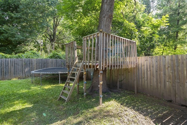 view of yard with a trampoline and a playground