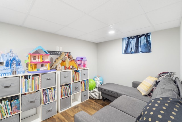 recreation room featuring a drop ceiling and hardwood / wood-style floors