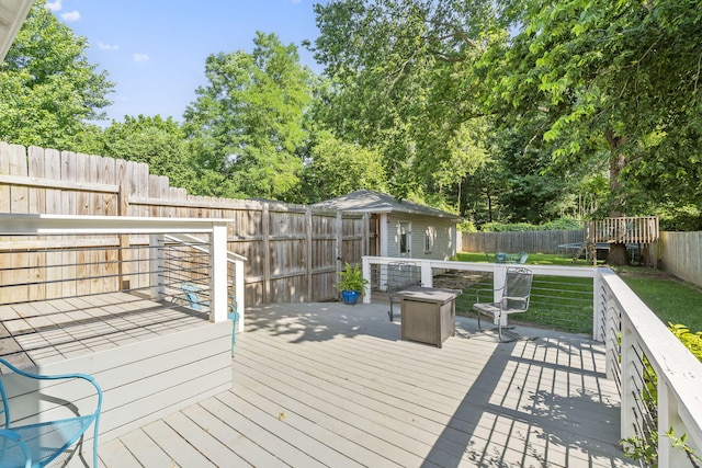 wooden terrace with an outdoor structure and an outdoor fire pit