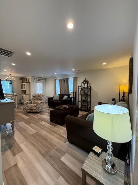 living room featuring an inviting chandelier and light wood-type flooring