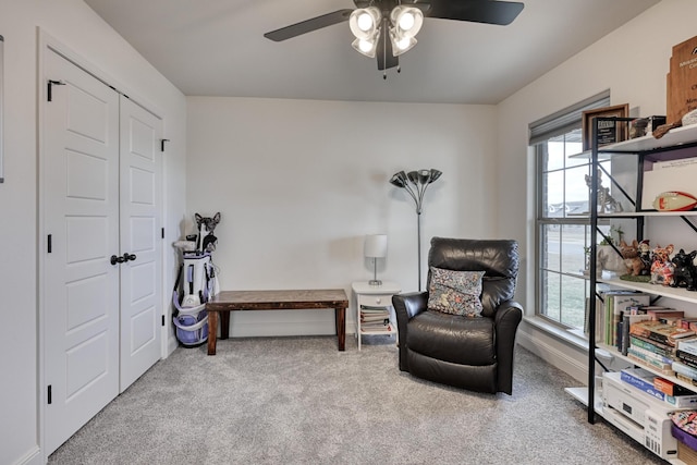 living area featuring a healthy amount of sunlight, carpet flooring, and ceiling fan