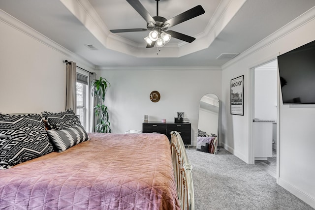 carpeted bedroom featuring crown molding, a tray ceiling, and ceiling fan