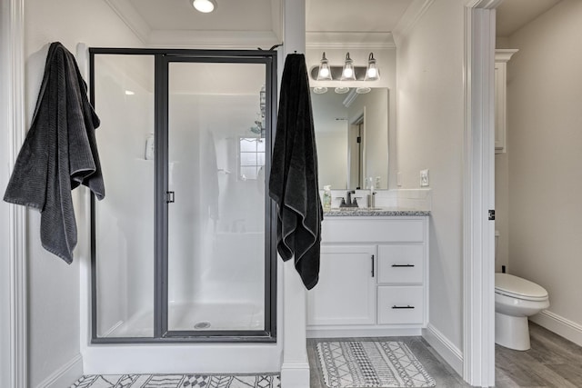 bathroom with vanity, a shower with shower door, ornamental molding, and toilet