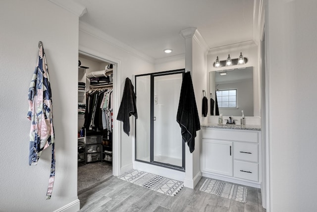 bathroom featuring walk in shower, vanity, crown molding, and hardwood / wood-style floors