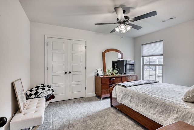 carpeted bedroom featuring ceiling fan and a closet