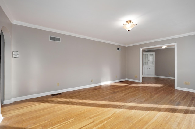 empty room featuring hardwood / wood-style flooring and ornamental molding