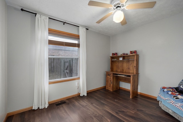 interior space with ceiling fan, dark wood-type flooring, and a textured ceiling