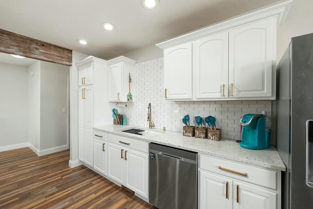 kitchen featuring appliances with stainless steel finishes, sink, white cabinets, backsplash, and light stone counters