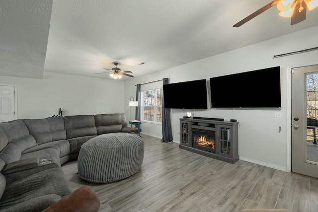 living room with ceiling fan and light wood-type flooring