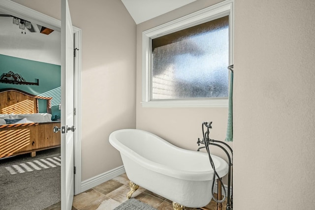 bathroom featuring tile patterned floors, lofted ceiling, and a bath