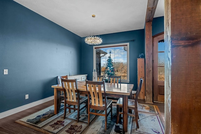 dining space with hardwood / wood-style floors and a chandelier