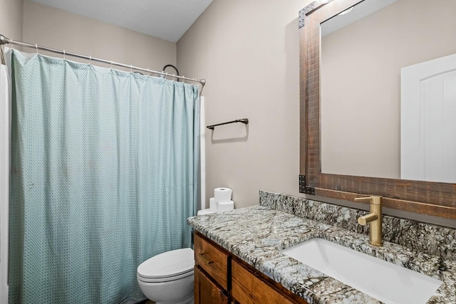 bathroom featuring vanity, curtained shower, and toilet