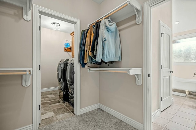 laundry room featuring separate washer and dryer and light carpet