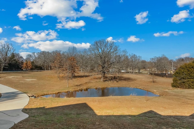 view of swimming pool featuring a water view and a lawn