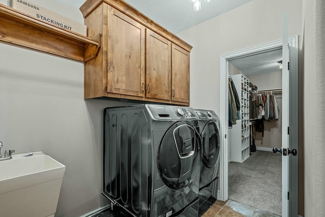 laundry room with light carpet, cabinets, sink, and washer and dryer