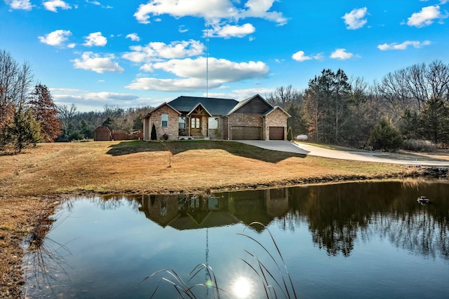 back of house featuring a water view, a garage, and a yard