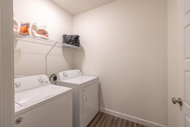 clothes washing area with washing machine and dryer and dark hardwood / wood-style flooring