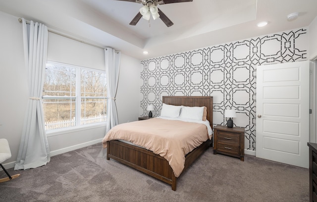 bedroom with ceiling fan, a tray ceiling, and carpet floors