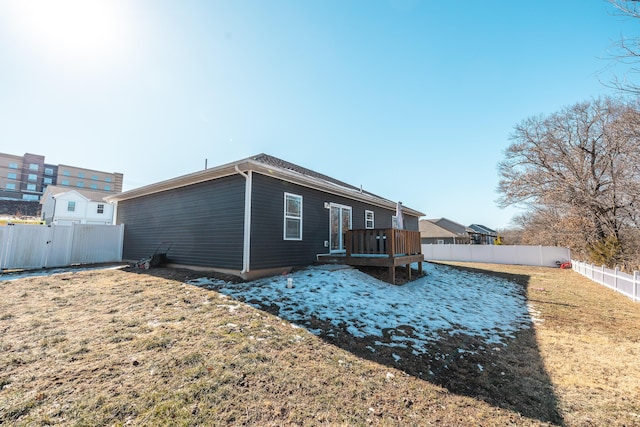 rear view of property with a deck and a lawn