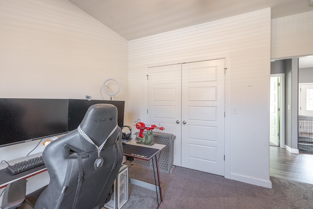 office space featuring lofted ceiling and dark colored carpet