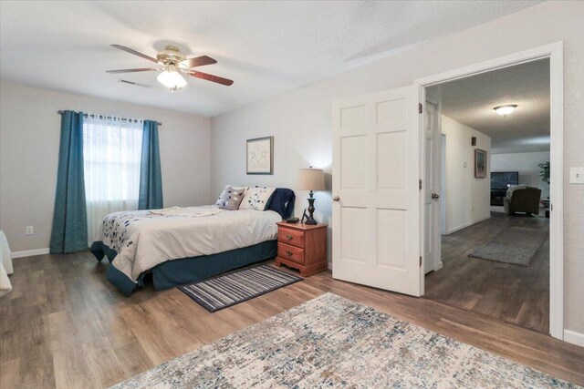 bedroom featuring wood-type flooring, a textured ceiling, and ceiling fan