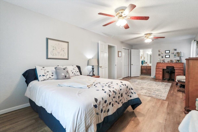 bedroom with connected bathroom, hardwood / wood-style flooring, a textured ceiling, and ceiling fan