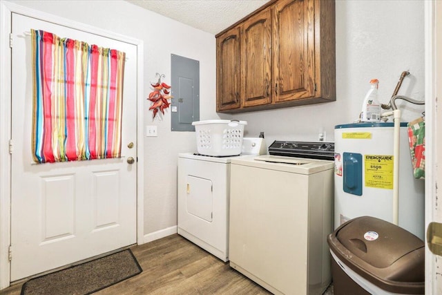 clothes washing area featuring water heater, wood-type flooring, cabinets, electric panel, and washer and clothes dryer