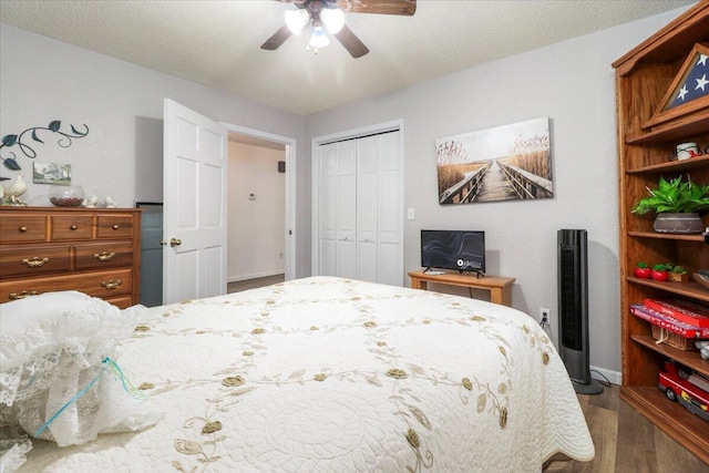 bedroom with dark hardwood / wood-style flooring, a textured ceiling, a closet, and ceiling fan