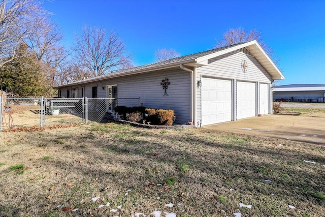 view of side of property with a garage and a lawn