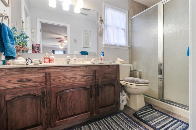 bathroom featuring vanity, toilet, and a shower with door